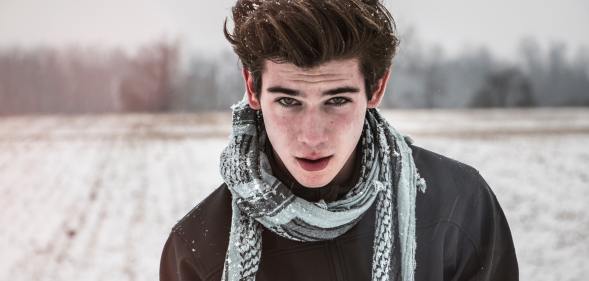 Man in snowy setting stares intensely at the camera