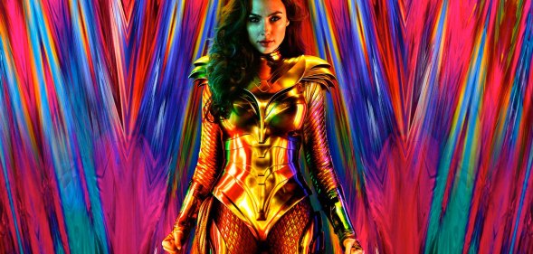 Gal Gadot as Wonder Woman in a gold suit in front of a multicoloured backdrop