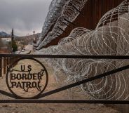 A metal fence marked with the US Border Patrol sign prevents people to get close to the barbed wire covering the US/Mexico border fence