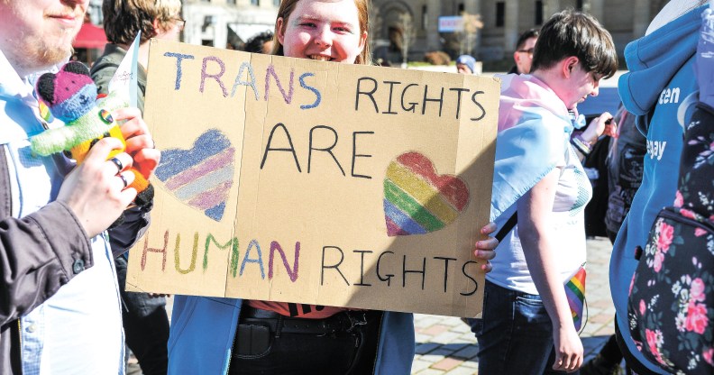 A participant is seen holding a placard during the 2019 Trans Pride march in Dundee.