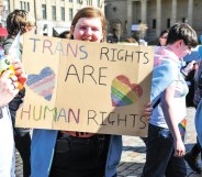 A participant is seen holding a placard during the 2019 Trans Pride march in Dundee.