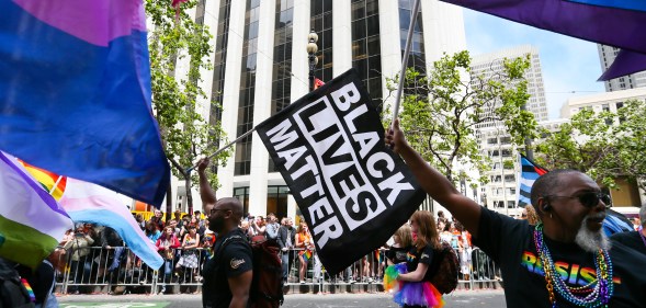 Men wave rainbow and 'black lives matter' flags while marching in the annual LGBTQI Pride Parade on Sunday, June 25, 2017 in San Francisco, California.