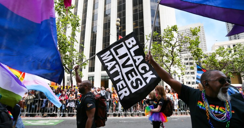 Men wave rainbow and 'black lives matter' flags while marching in the annual LGBTQI Pride Parade on Sunday, June 25, 2017 in San Francisco, California.