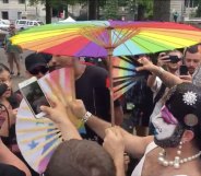 Drag queens in white paint flicking hand fans