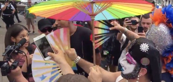 Drag queens in white paint flicking hand fans