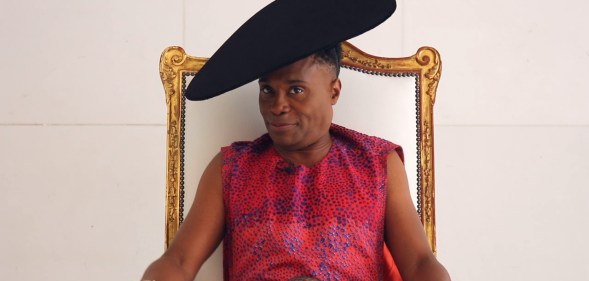 Billy Porter, wearing a dress and sat in a throne, speaks exclusively to PinkNews