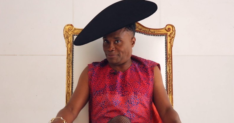 Billy Porter, wearing a dress and sat in a throne, speaks exclusively to PinkNews