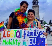Crstina Palma and her wife holding a sign reading "LGBTQI family mobility in EU"
