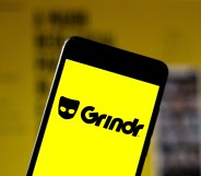 A phone showing a yellow screen with the Grindr logo