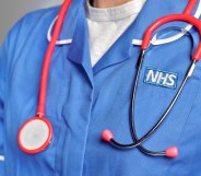 A close-up of somebody wearing an NHS uniform with a stethoscope around their neck.