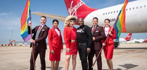 LGBT+ flight crew hold rainbow flags alongside Jodie Harsh and Tituss Burgess