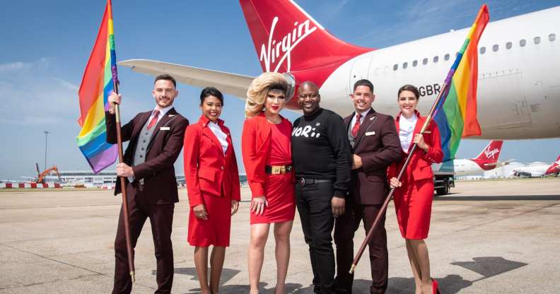 LGBT+ flight crew hold rainbow flags alongside Jodie Harsh and Tituss Burgess