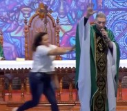 Woman pushes anti-gay priest off stage in Brazil