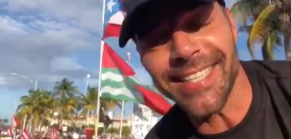 Ricky Martin in front of a Puerto Rican flag