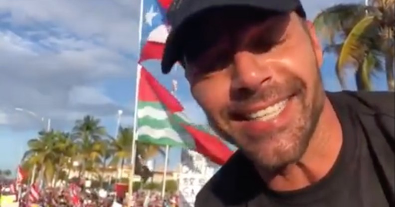 Ricky Martin in front of a Puerto Rican flag