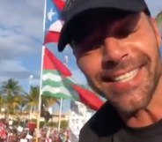 Ricky Martin in front of a Puerto Rican flag