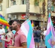 Protestors holding rainbow and trans flags