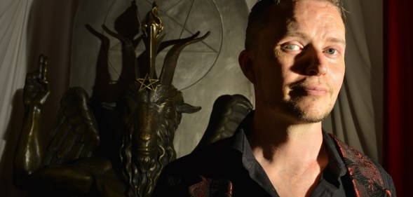 Lucien Greaves, spokesman for The Satanic Temple, with a statue of Baphomet at the group's meeting house in Salem, Massachusetts.