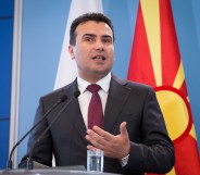 Zoran Zaev speaking in front of a North Macedonia flag.