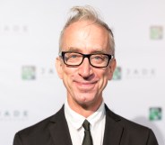 Andy Dick smiling, wearing a suit and black tie