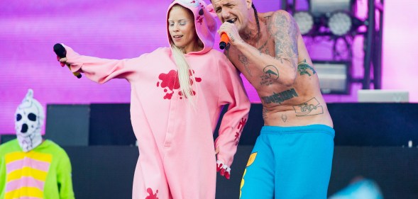Die Antwoord's Yolandi in a pink onesie and Ninja in blue trousers