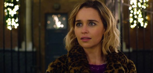 Emilia Clarke looking wide-eyed in a leopard-print coat