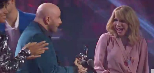 John Travolta handing an award to Jade Jolie