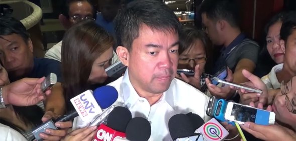 Koko Pimintel surrounded by microphones