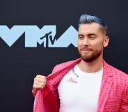 Lance Bass pulling his jacket aside to show the 'Tearin' Up My Heart' message on his t-shirt