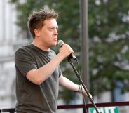 Owen Jones speaking into a microphone at a rally