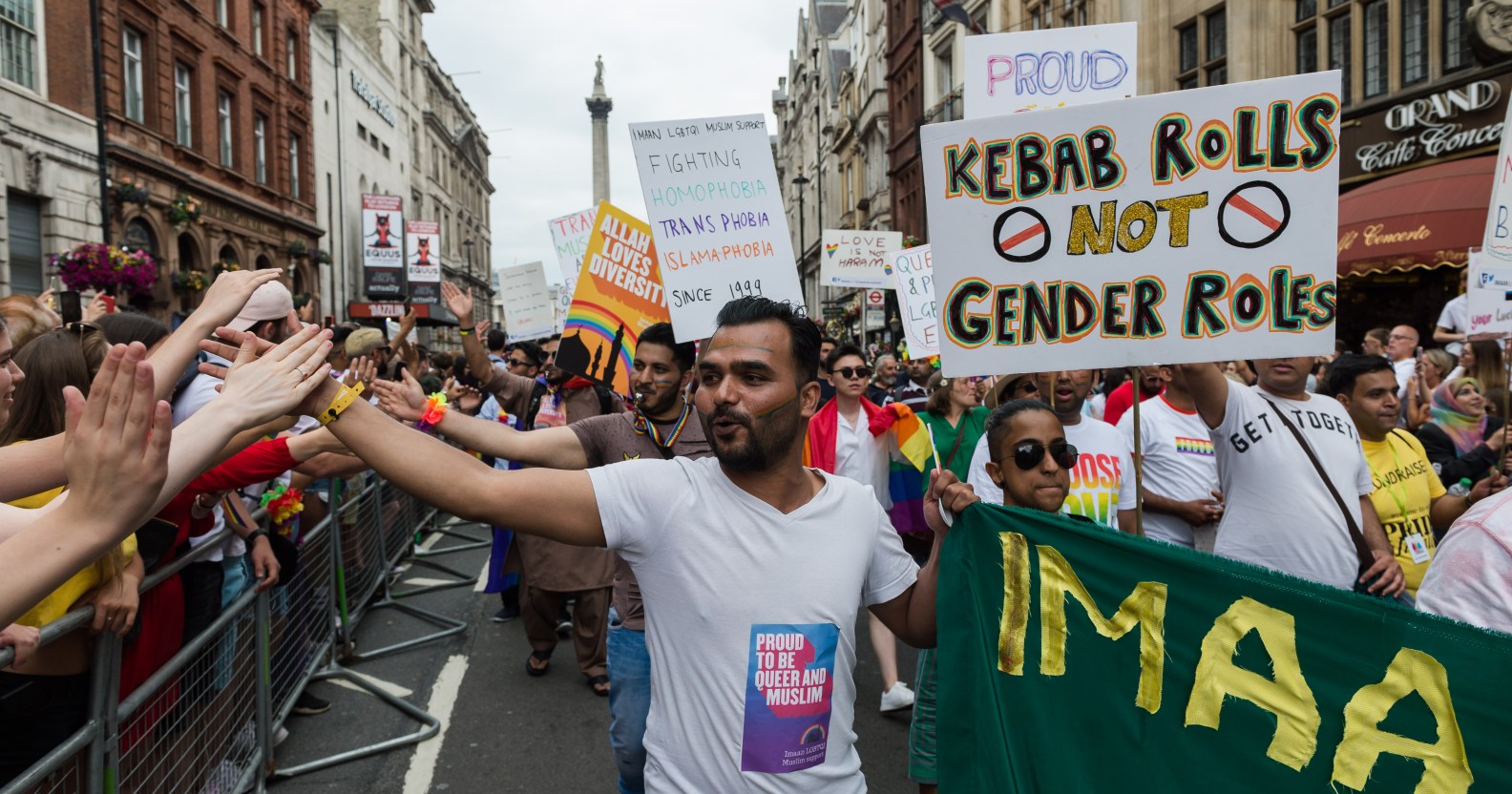 A photo from the UK's first ever Muslim LGBT Pride festival showing a Muslim man holding his hand out to the crowd lining the streets