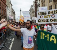 A photo from the UK's first ever Muslim LGBT Pride festival showing a Muslim man holding his hand out to the crowd lining the streets