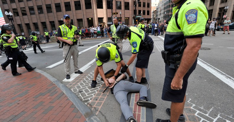Boston Police officers arrest an anti-parade demonstrator during the "Straight Pride" parade in Boston, on August 31, 2019.