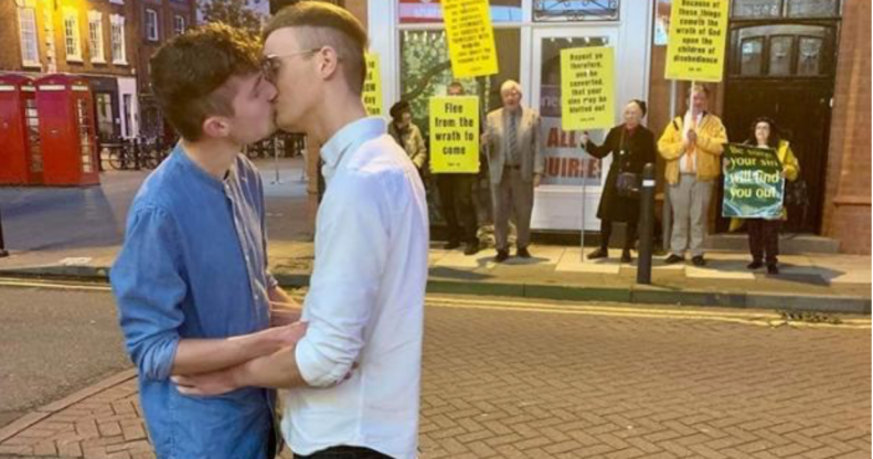 A gay couple showed their defiance against a group of religious protesters in the best way possible. (Joe Fergus and Robert Brookes)