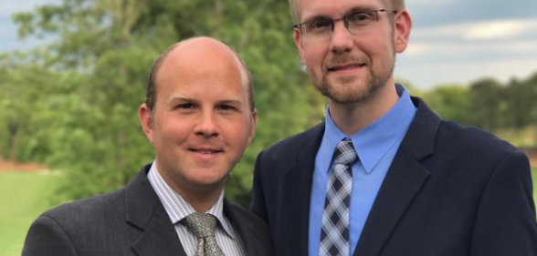 Joshua Payne-Elliott (right) and his husband, Layton Payne-Elliott, were both employed as Catholic school teachers before Joshua was fired.