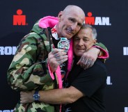 Gareth Thomas shows his finishers medal as he celebrates with his partner on completing his first Ironman triathlon. (Huw Fairclough/Getty Images)