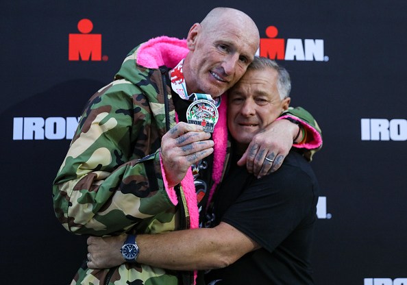 Gareth Thomas shows his finishers medal as he celebrates with his partner on completing his first Ironman triathlon. (Huw Fairclough/Getty Images)