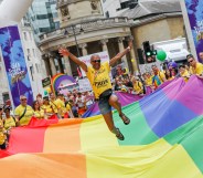 A general view a flag bearer jumping on the giant Pride flag during Pride in London 2019 on July 06, 2019 in London, England.