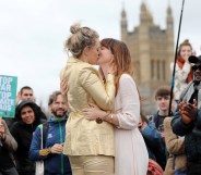Tasmin and Melissa embrace after they received a blessing ahead of their wedding day, surrounded by activists from the climate change group Extinction Rebellion, during a demonstration on Westminster Bridge