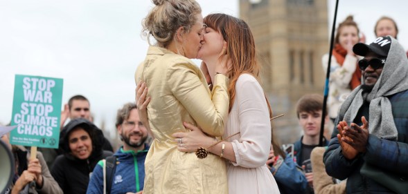 Tasmin and Melissa embrace after they received a blessing ahead of their wedding day, surrounded by activists from the climate change group Extinction Rebellion, during a demonstration on Westminster Bridge