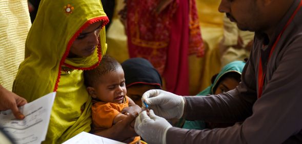 A Pakistani paramedic takes a blood sample from a baby for a HIV test in Ratodero