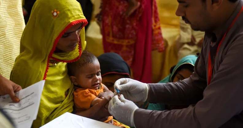 A Pakistani paramedic takes a blood sample from a baby for a HIV test in Ratodero