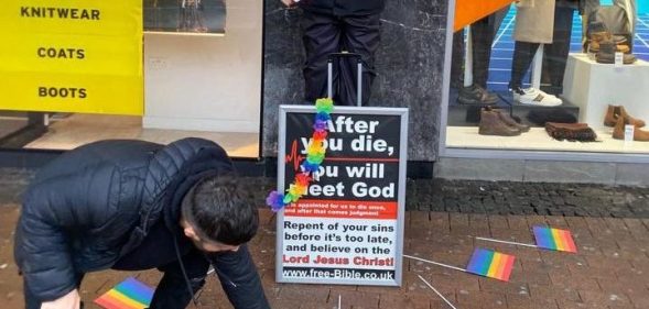 rainbow flags around street preacher