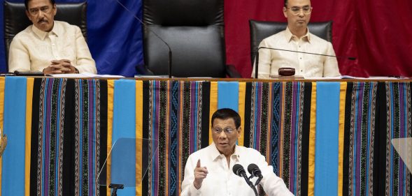 Philippine President Rodrigo Duterte gestures as he delivers his state of the nation address, as Senate President Vicente Sotto the III (top L) and House Speaker Alan Peter Cayetano (top R) look on at Congress. (NOEL CELIS/AFP via Getty Images)