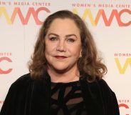 A photo shows actor Kathleen Turner wearing a black dress and smiling at the camera during a press event at the Women's Media Awards