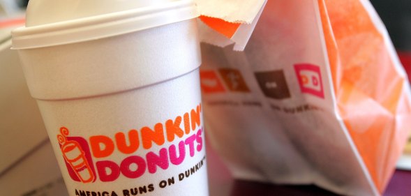 A cup of Dunkin' Donuts coffee and a donut bag sit on a counter. (Tim Boyle/Getty Images)