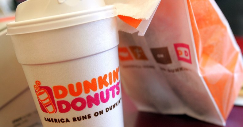 A cup of Dunkin' Donuts coffee and a donut bag sit on a counter. (Tim Boyle/Getty Images)