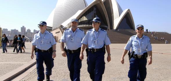 Police officers patrol in front of the Sydney Opera House