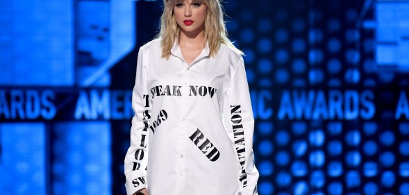 Taylor Swift wearing a shirt with the names of her first six albums at the AMAs
