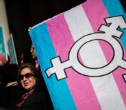 An LGBT+ activist holding the trans flag